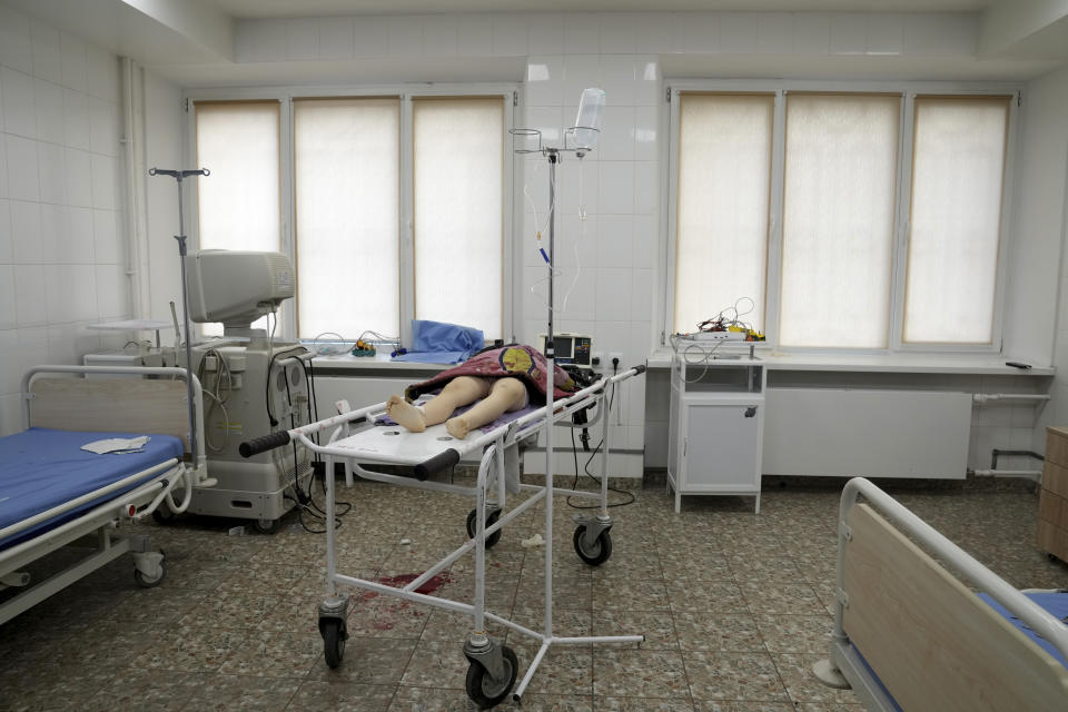 FILE - The lifeless body of a girl killed during the shelling of a residential area lies on a medical cart at the city hospital of Mariupol, eastern Ukraine, Sunday, Feb. 27, 2022. (AP Photo/Evgeniy Maloletka)