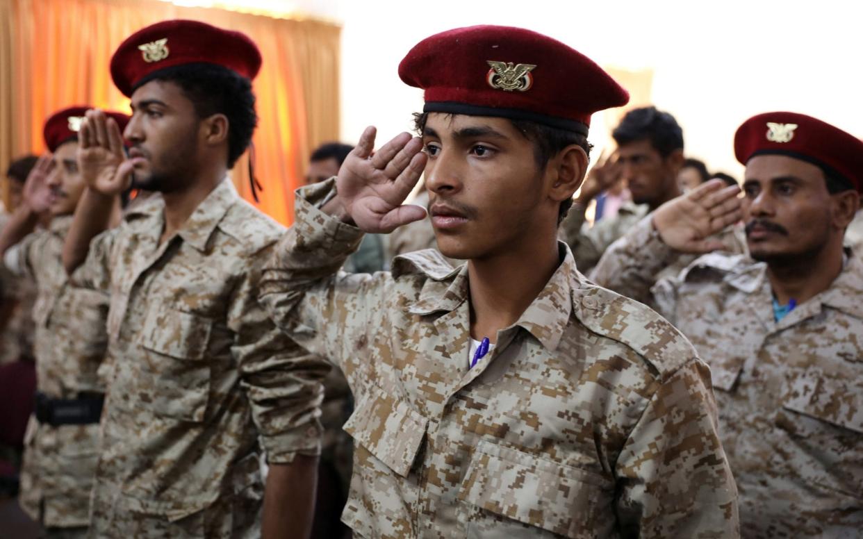 Soldiers who have defected from the ranks of Yemeni government forces salute for the national anthem during a ceremony held by the Houthis in Sanaa - REUTERS