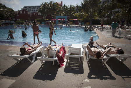 Spring breakers lay by the pool at a hotel in Cancun March 14, 2015. REUTERS/Victor Ruiz Garcia