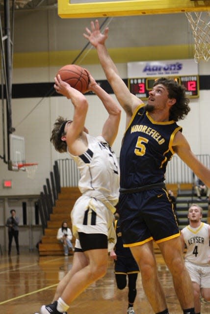 Keyser's Noah Broadwater takes it to the hoop while being defended by Moorefield's Coleman Mongold. Moorefield was victorious by a score of 60-46.