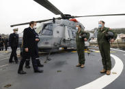 French President Emmanuel Macron meets crew members of a NH90 Caiman helicopter prior to his New Year's speech to the French Armed Forces at Brest naval training center, western France, Tuesday, Jan. 19, 2021. (Stephane Mahe/Pool Photo via AP)