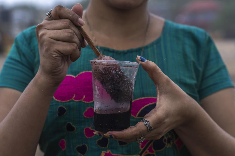 A girl hold a plastic glass as she prepares to drink Shaved ice at Juhu beach in Mumbai, India, Thursday, June 30, 2022. India banned some single-use or disposable plastic products Friday as a part of a longer federal plan to phase out the ubiquitous material in the nation of nearly 1.4 billion people. (AP Photo/Rafiq Maqbool)