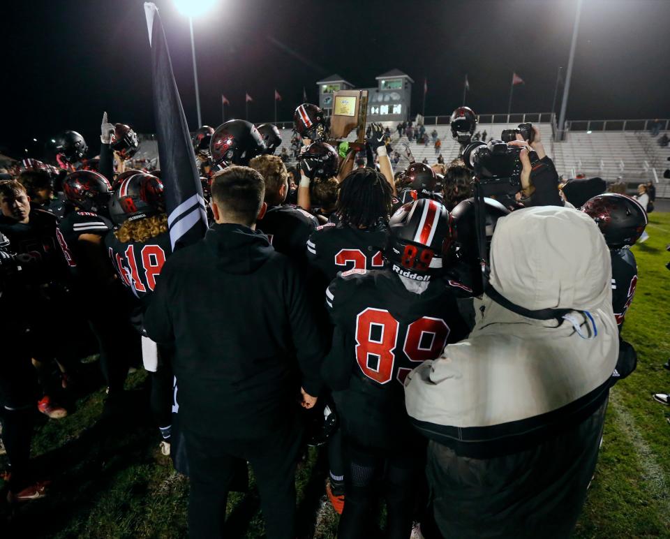 The NorthWood football team raises the Class 4A regional championship trophy after defeating New Prairie, 38-14, Friday at Andrews Field in Nappanee.