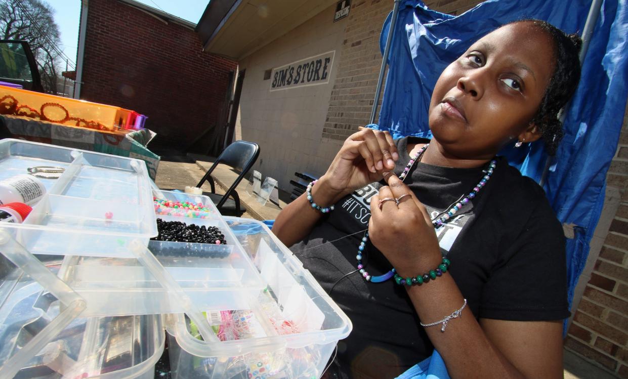 Walasia Vinson, a cancer survivor who eventually went blind, makes colorful jewelry for sale at her table outside Sims Grocery on Buffalo Street in Shelby Friday afternoon, March 4, 2022.