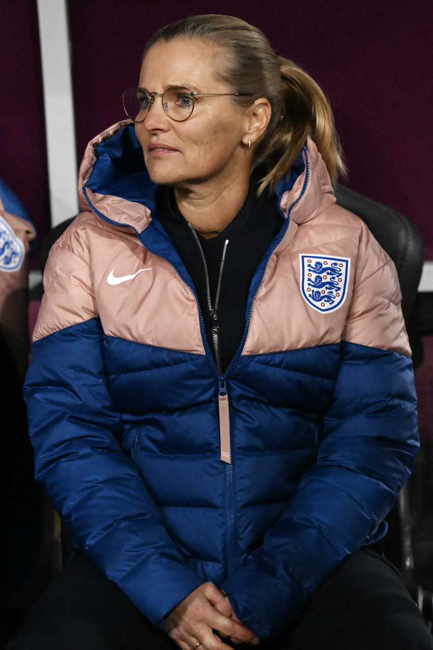 Sarina Wiegman sitting on the sideline during a match