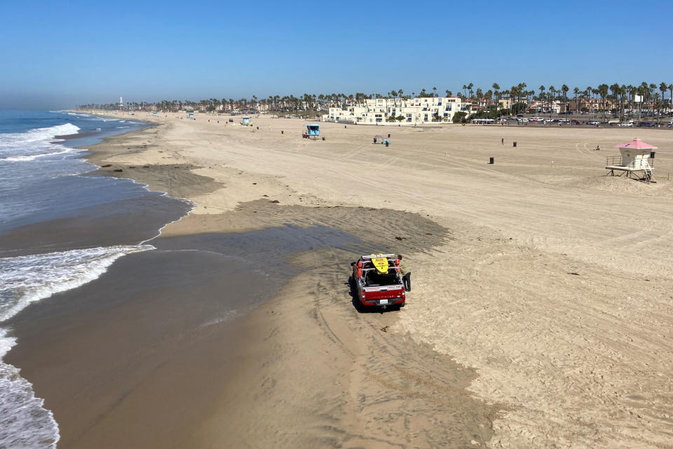 Few people visit the beach a week after the ocean was closed to surfing and swimming due to an offshore pipeline leak in Huntington Beach, Calif., Sunday, Oct. 10, 2021. Access the Ocean water has been shut to surfing and swimming for a week since an offshore oil pipeline leaked crude into the water off the coast of Orange County. (AP Photo/Amy Taxin)