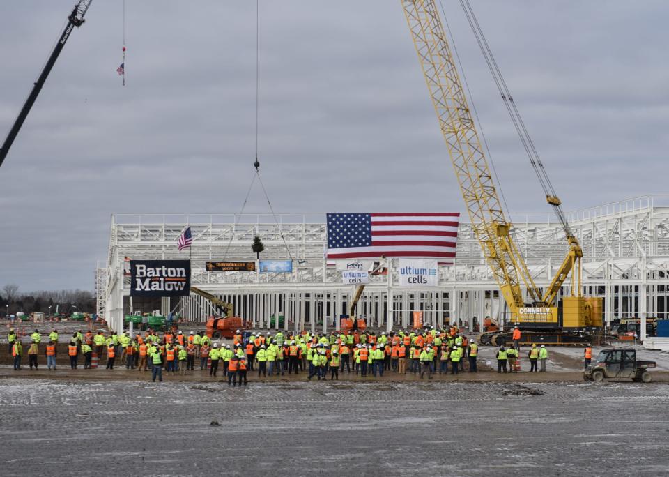 Iron workers, construction partners, and Ultium Cells leadership celebrate the placement of the final truss in the Ultium Cells battery plant during a "topping off" ceremony in Delta Township, Friday, Feb. 24, 2023,