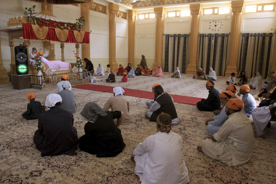 Members of the Sikh community take part in worship at the Gurudawara Sri Guru Singh Sabha temple in Quetta, Pakistan, Thursday, July 23, 2020. The 200-year-old Sikh temple that served as a school for Muslim girls for seven decades was returned to the Sikh community in the city of Quetta, enabling them to worship there for the first time in 73 years, officials said Thursday. (AP Photo/Arshad Butt)