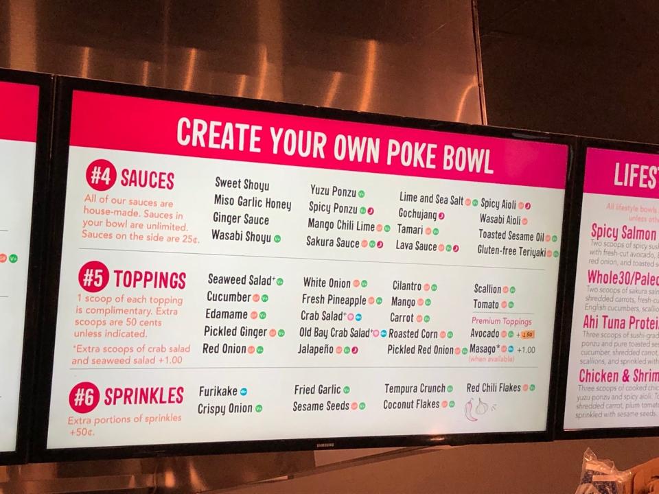 A menu at Poke Papa showing the different types of sauces, toppings, and sprinkles that patrons can order, including mango, pineapple, and red chili flakes.