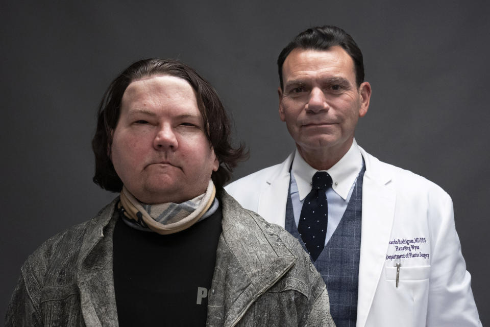 Joe DiMeo and his plastic surgeon Dr. Eduardo Rodriguez pose for a portrait, Monday, Jan. 25, 2021, in New York. In the months since his face and double hand transplant, DiMeo has not shown any signs of rejecting his new face or hands, said Rodriguez, the director of NYU Langone’s Face Transplant Program. (AP Photo/Mark Lennihan)