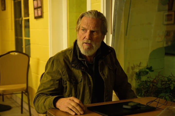 Jeff Bridges sitting at a table in 'The Old Man.' 