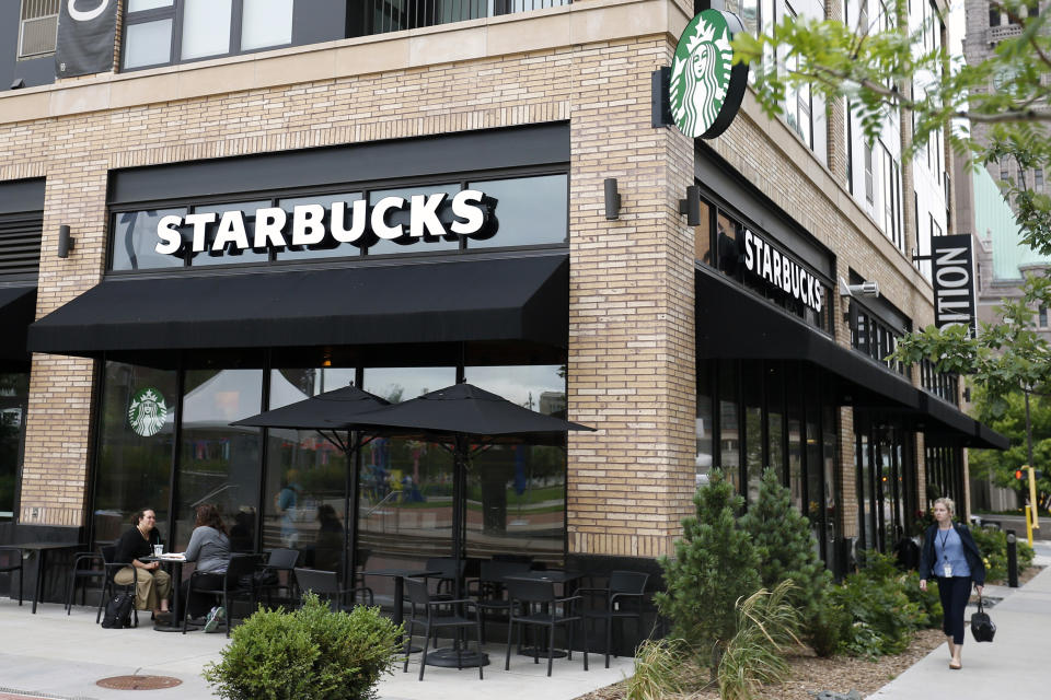 In this July 10, 2019, photo customers visit at a Starbucks in Minneapolis. Starbucks Corp. reports financial earnings on Thursday, July 25, 2019. (AP Photo/Jim Mone)