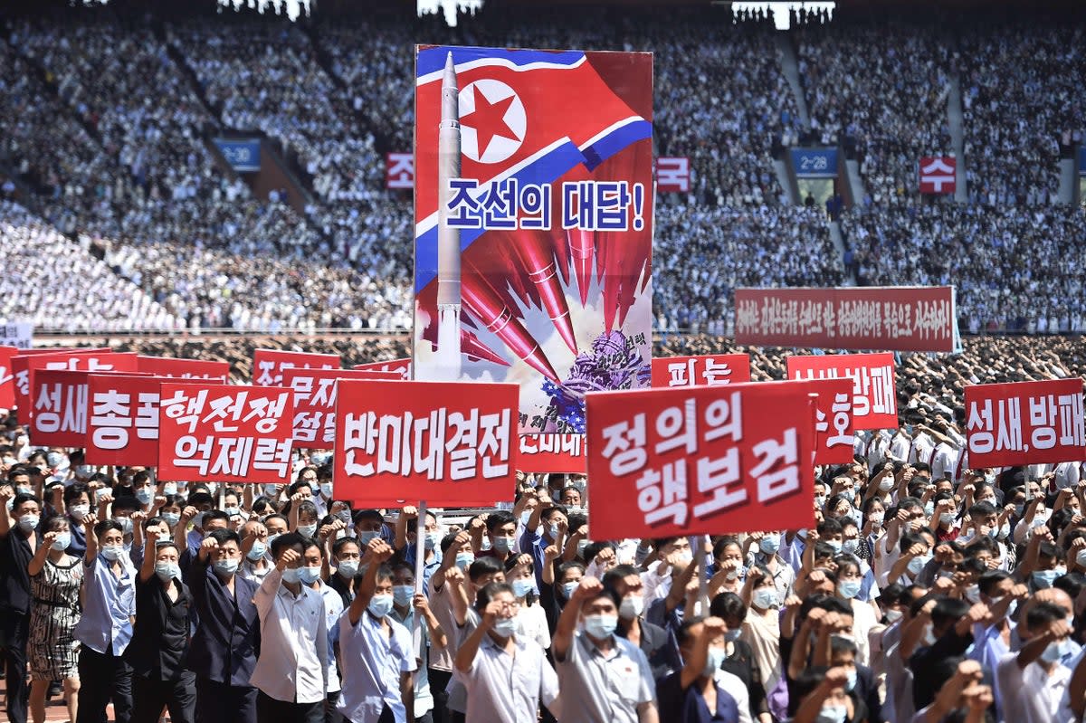 People in Pyongyang hold banners that read 