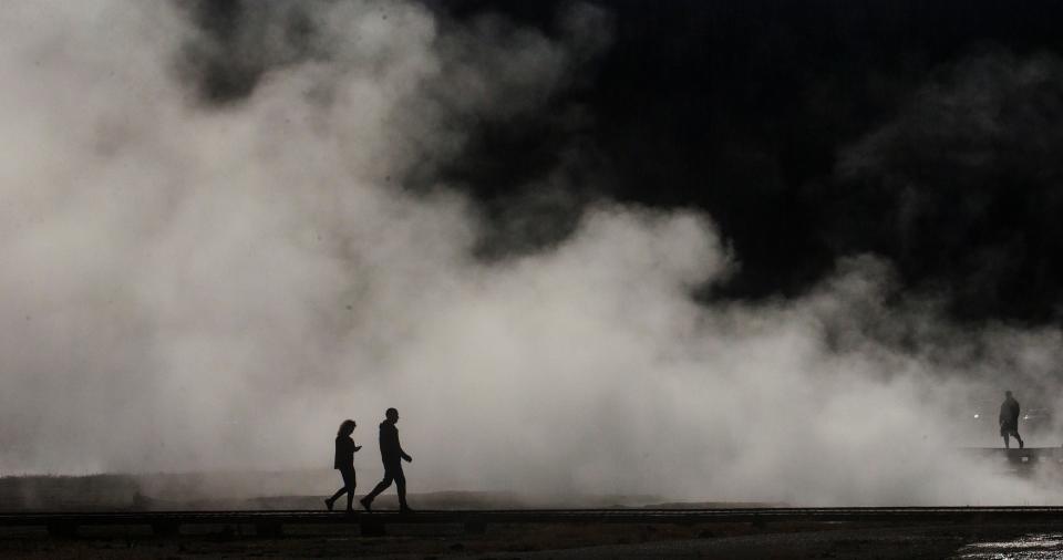 Visitors to Biscuit Basin loop at Yellowstone National Park tour the thermal features on June 25, 2021.