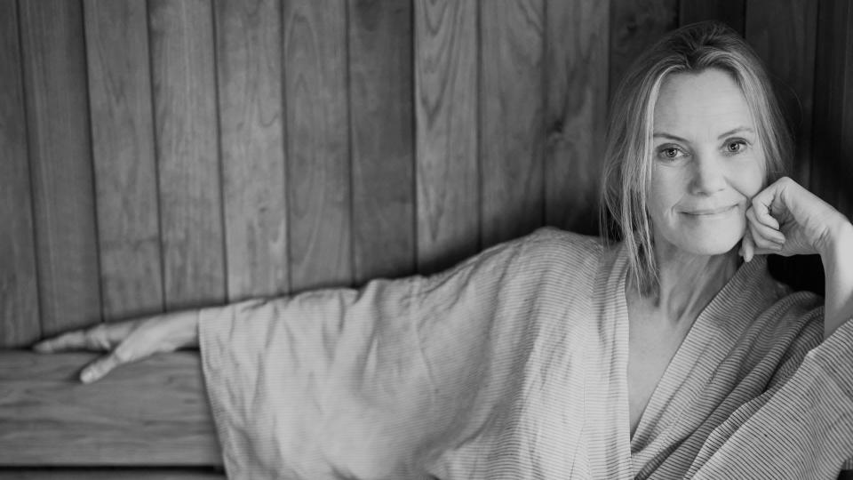 Woman smiling in a robe in the sauna