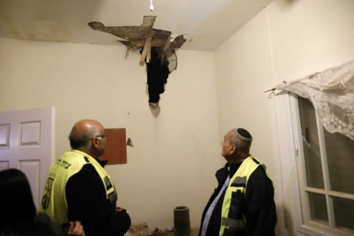 Israeli volunteer rescuers check damage in house in the southern Israeli town of Sderot, caused by a rocket fired from the Gaza Strip on March 25, 2019