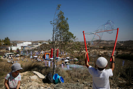 Children play during an event organised to show support for the Jewish settler outpost of Amona in the West Bank, that was built without Israeli state authorisation and which Israel's high court ruled must be evacuated and demolished by the end of the year as it is built on privately-owned Palestinian land, October 20, 2016. REUTERS/Ronen Zvulun/File Photo