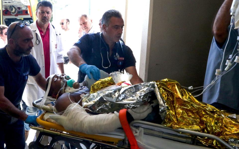 Emergency workers use a trolley to take as a person injured in an earthquake - Credit: COSTS METAXAKIS/Getty