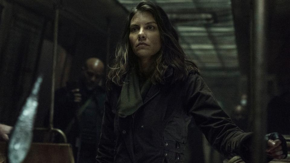 Lauren Cohan as Maggie Rhee stands in a dark, abandoned subway station