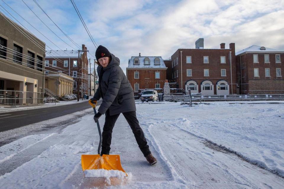 Isaiah Vanderwater, of SP Plus, shovels snow from a sidewalk in downtown Lexington, Ky., on Thursday, Jan. 22, 2022.