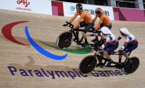 FILE - In this Aug. 25, 2021, file photo, Tristan Bangma, top right, and his pilot Patrick Bos, top left, of the Netherlands compete with Britain's Adam Duggleby, right, and his pilot Stephen Bate in the Cycling Track men's B 4000m Individual Pursuit final at the Tokyo 2020 Paralympic Games in Izu, Shizuoka prefecture, Japan. There are 4,403 Paralympic athletes competing in Tokyo, each with unique differences that have to be classified. Lines have to be draw, in the quest for fairness, to group similar impairments, or impairments that yield similar results. (AP Photo/Shuji Kajiyama)