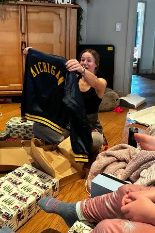 <p>Instagram</p> Kristen Bell opening Christmas presents in her living room