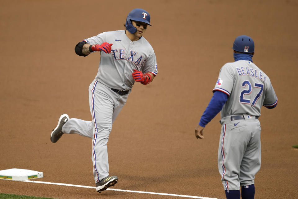 Texas Rangers' Shin-Soo Choo, left, celebrates with third base coach Tony Beasley after hitting a home run against the Oakland Athletics in the first inning of a baseball game Wednesday, Aug. 5, 2020, in Oakland, Calif. (AP Photo/Ben Margot)