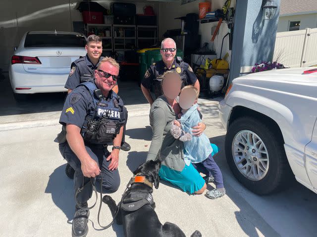 <p>DeLand Police Department/Facebook</p> DeLand police officers with K-9 Midnight and the missing 3-year-old boy the dog located in the woods