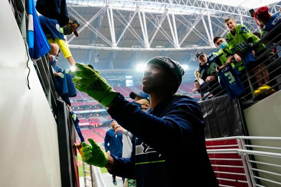 Seattle Seahawks wide receiver Tyler Lockett signs autographs for fans prior to an NFL football game against the Arizona Cardinals Sunday, Jan. 9, 2022, in Glendale, Ariz. (AP Photo/Ralph Freso) Ralph Freso/AP