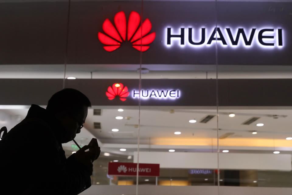 FILE - In this Dec. 6, 2018, file photo, a man lights a cigarette outside a Huawei retail shop in Beijing. The Federal Communications Commission on Friday, Nov. 22, 2019 voted, 5-0, to bar U.S. telecommunications providers from using government subsidies to pay for networking equipment from companies that are a threat to national security. The agency says China’s Huawei and ZTE pose such a threat. (AP Photo/Ng Han Guan, File)