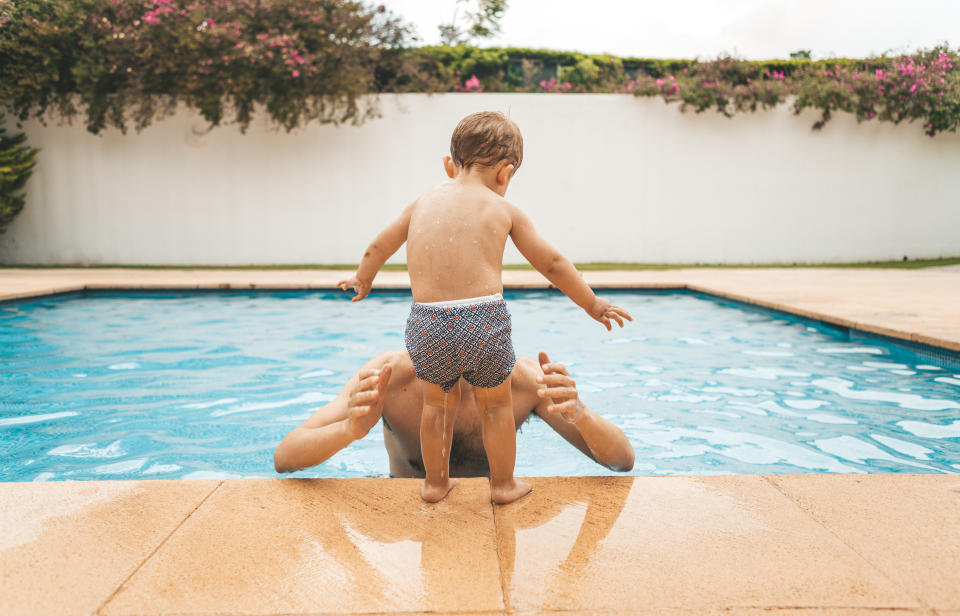 young toddler and father swimming at the pool