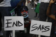 People protest against police brutality in Lagos, Nigeria, Sunday Oct. 18, 2020. Nigerian protests against police brutality continued Sunday for the eleventh day, with demonstrators fending off attacks from gangs suspected to be backed by the police, warnings from the Nigerian military, and a government order to stop because of COVID-19. (AP Photo/Sunday Alamba)