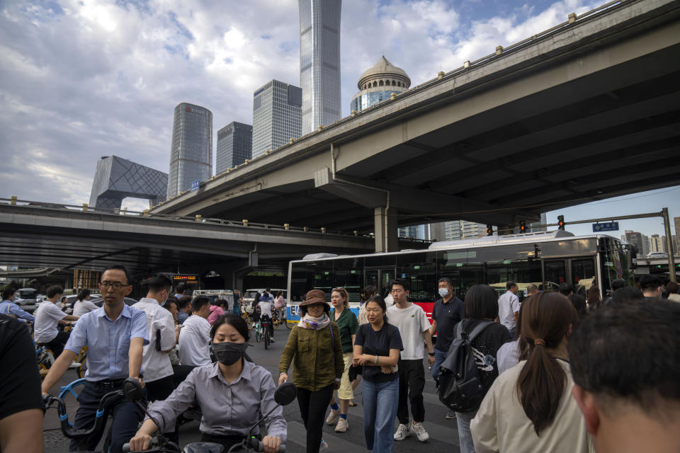 FILE - Commuters walk across an intersection during the evening rush hour in the central business district in Beijing, on June 13, 2023. China's economy grew 6.3% in the second quarter, missing expectations even after near-stagnant growth from a year ago.(AP Photo/Mark Schiefelbein, File)