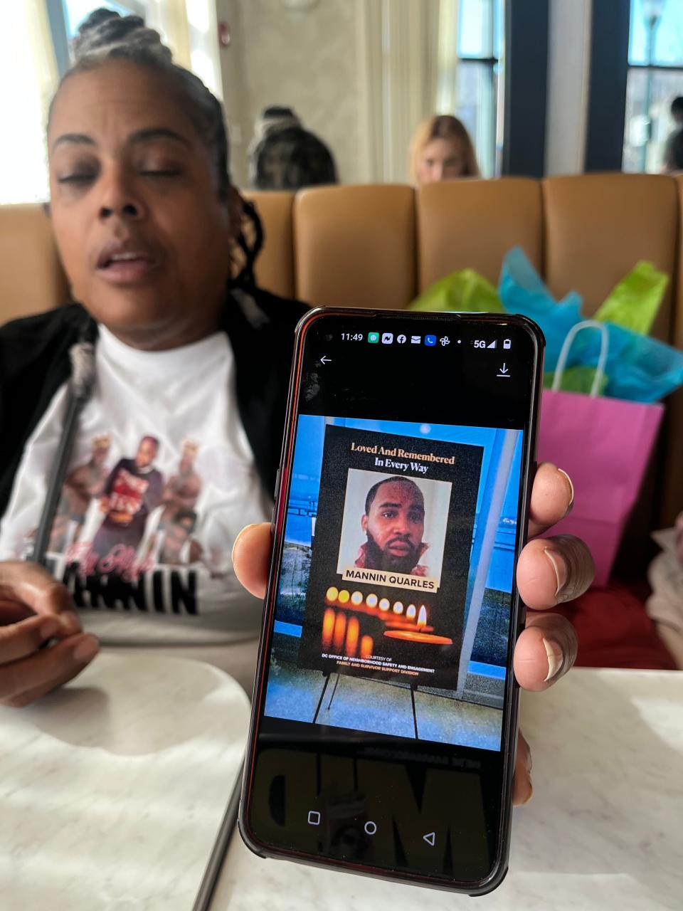 Lisha Quarles holds up a photo of her son, Mannin Quarles, Sr., who was killed in a shooting on Sept. 1.