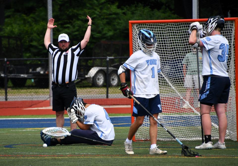 While an official signals a goal, York goalie Evan Giacobba, left, and defenders Laird Masterson and Shea Buckley feel the pain of losing in sudden death overtime to Yarmouth, 13-12, in the Class B championship game Saturday morning at Fitzpatrick Stadium in Portland, Maine.