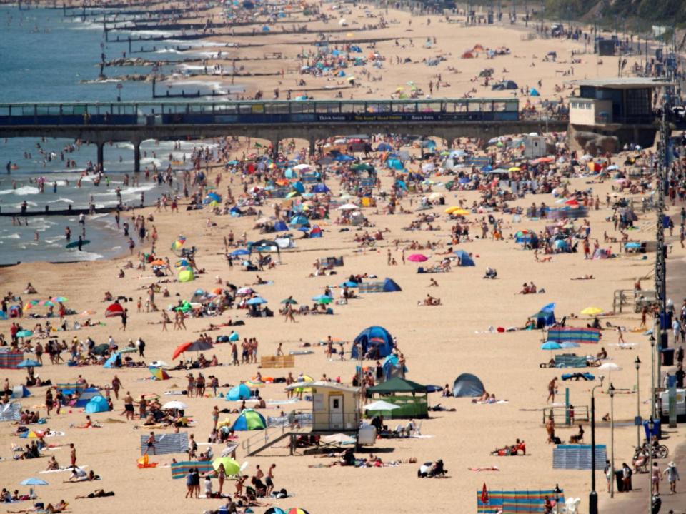 Sunbathers enoy the warm weather on the beach near Boscombe Pier in Bournemouth: Photo by ADRIAN DENNIS/AFP via Getty Images