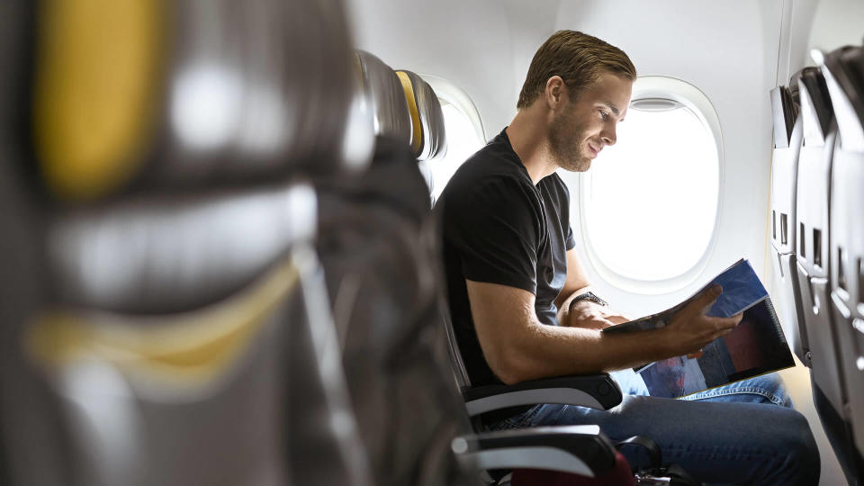 man reading magazine on airline