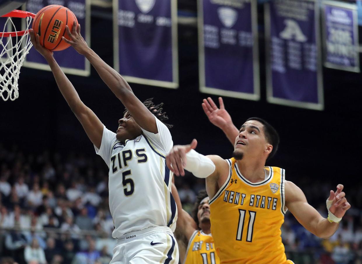 Akron Zips guard Tavari Johnson (5) attempts a layup ahead of Kent State Golden Flashes guard Giovanni Santiago (11) during the first half of an NCAA college basketball game, Friday, Feb. 23, 2024, in Akron, Ohio.
