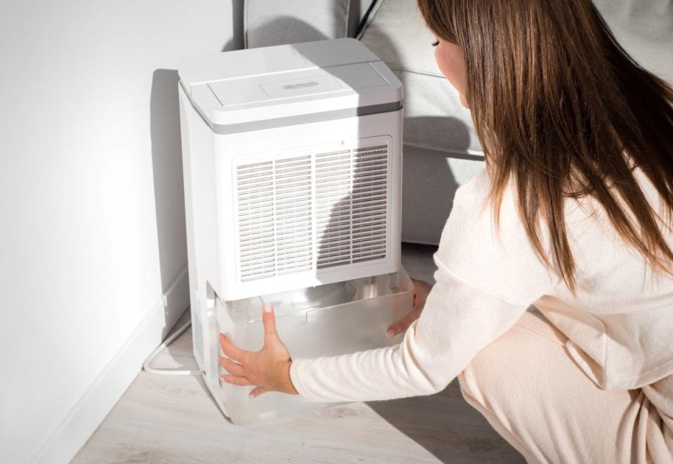 Woman pulling humidifier water container.