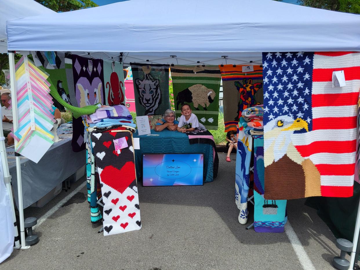 Dottie Lash poses for a photo with her handmade crocheted blankets at the Ozark Farmers Market at Finley Farms. Lash began crocheting blankets in August 2021.