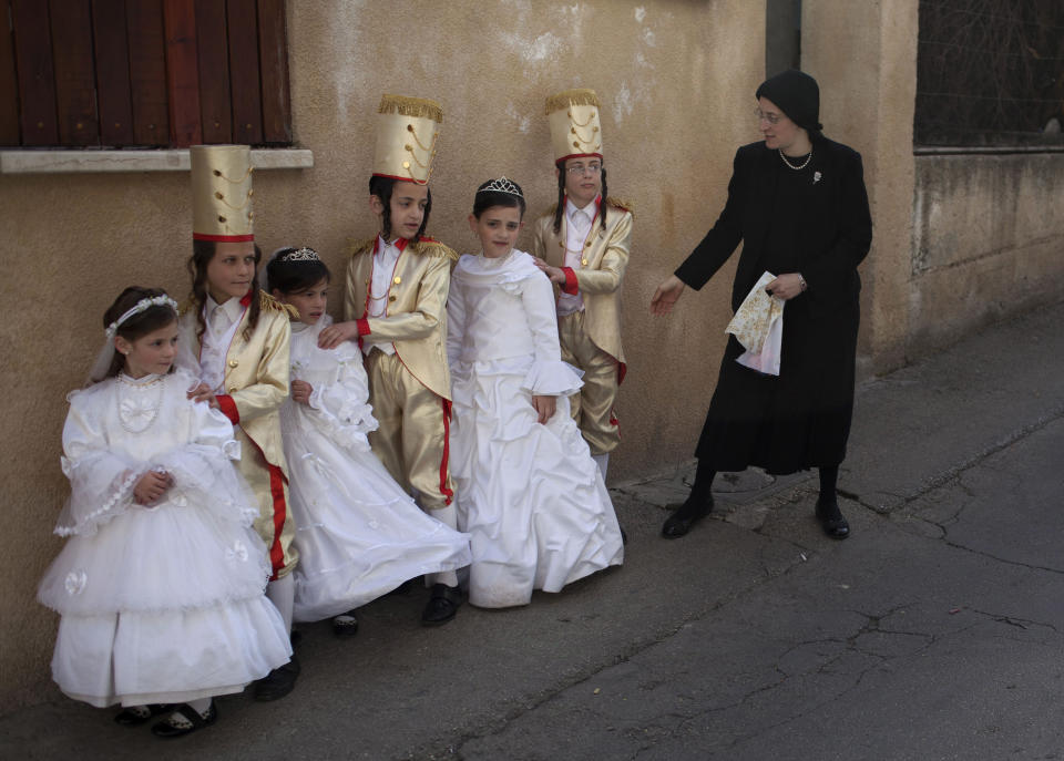 Ultra Orthodox Jewish girls and boys dressed in costumes pose as a woman, not seen, takes their picture during the Purim festival in the ultra-Orthodox Jewish neighborhood of Mea Shearim, Monday, Feb. 25, 2013. (AP Photo/Sebastian Scheiner)