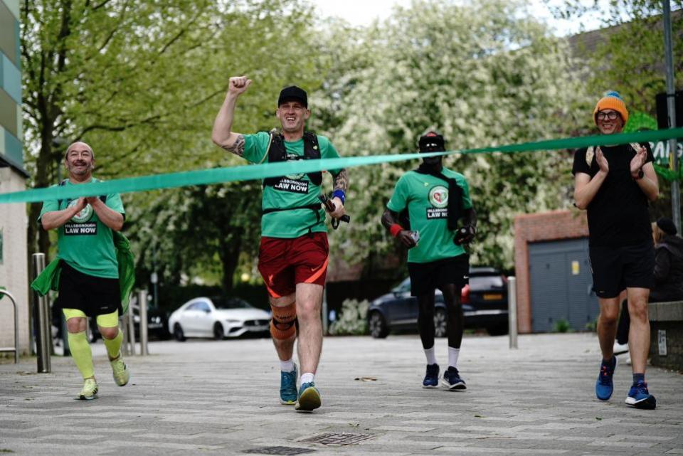 The Northern Echo: Mik Parkin, finishes his charity run for the Hillsborough Law campaign, from Liverpool to London at Grenfell Tower