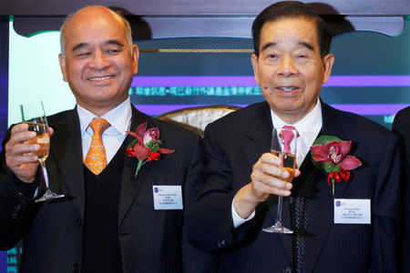 Chow Tai Fook Jewellery Group honorary chairman Cheng Yu-tung (R) and his son Henry Cheng Kar-shun, chairman of Chow Tai Fook Jewellery, toast during the trading debut of the company at the Hong Kong Stock Exchange, China December 15, 2011. REUTERS/Tyrone Siu/File photo