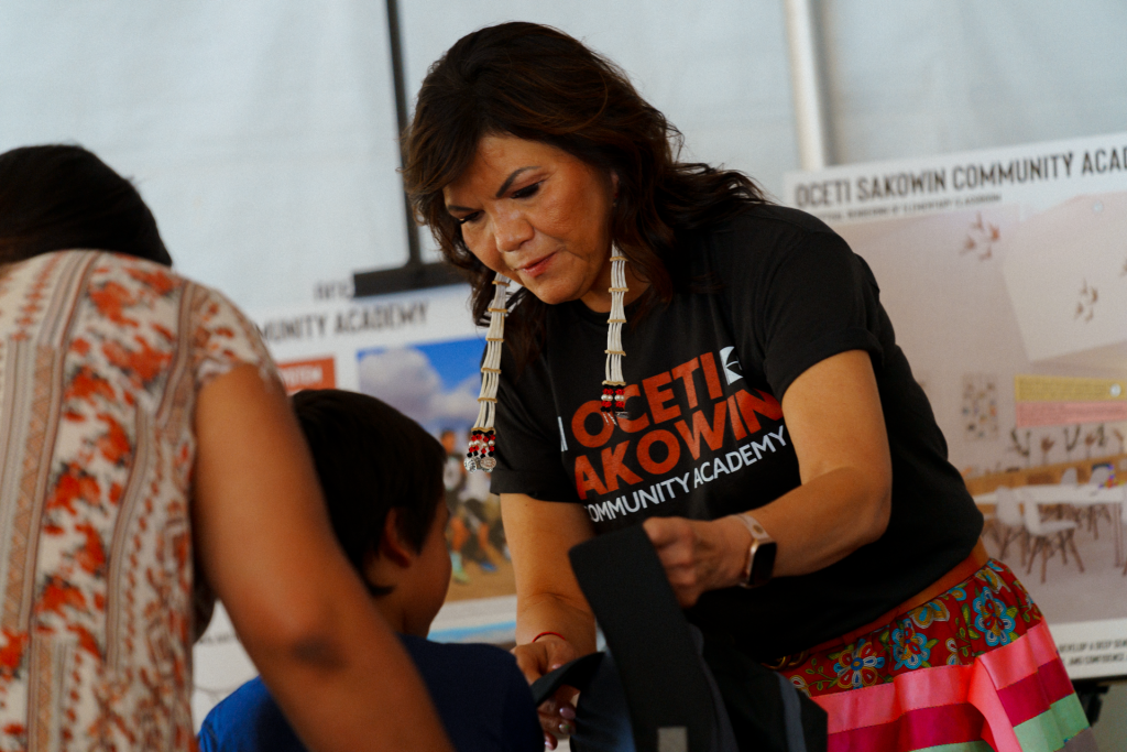 Mary Bowman, founder of the Oceti Sakowin Community Academy, gifts backpacks to students at the school’s grand opening event in September 2022 in Rapid City.