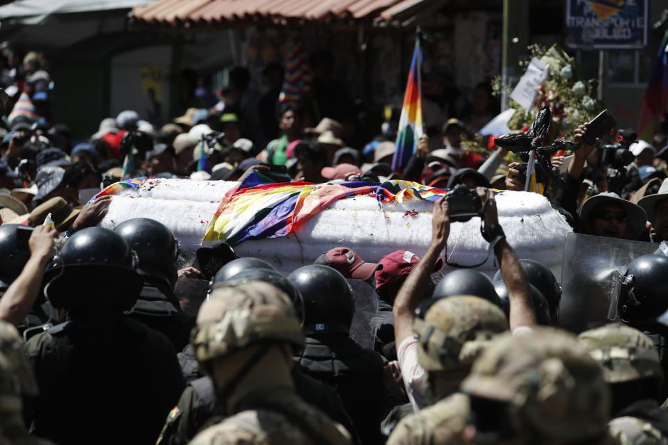 Mourners and anti-government demonstrators carry a coffin that contain the remains of a person killed in clashes between supporters of former President Evo Morales and security forces, in a funeral procession into La Paz, Bolivia, Thursday, Nov. 21, 2019. In an attempt to curb the social upheaval in Bolivia, interim President Jeanine Anez sent a bill to Congress to call for new elections amid an escalation of violence that has left 30 people dead. (AP Photo/Natacha Pisarenko)