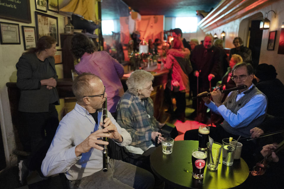 In this Dec. 31, 2019 photo, Richard Heitzman joins with fellow musicians to perform traditional Irish tunes in New York's William Barnacle Tavern, once a speakeasy during Prohibition. Americans are consuming more alcohol per capita now than in the time leading up to Prohibition, when alcohol opponents successfully made the case that excessive drinking was ruining family life. (AP Photo/Mark Lennihan)