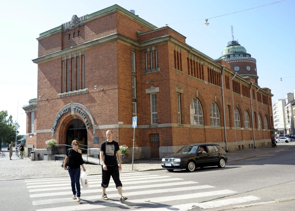 This July 8, 2011 photo shows people walking from the Hakaniemi Market Hall in Helsinki, Finland on July 8, 2011. The century-old Hakaniemi Market Hall offers 70 shops with an endless array of knickknacks, such as local delicacies (reindeer meat and blinis), alpaca jackets and other regional specialties from the northern Lapland to the north. (AP Photo/Lehtikuva, Sari Gustafsson) FINLAND OUT.