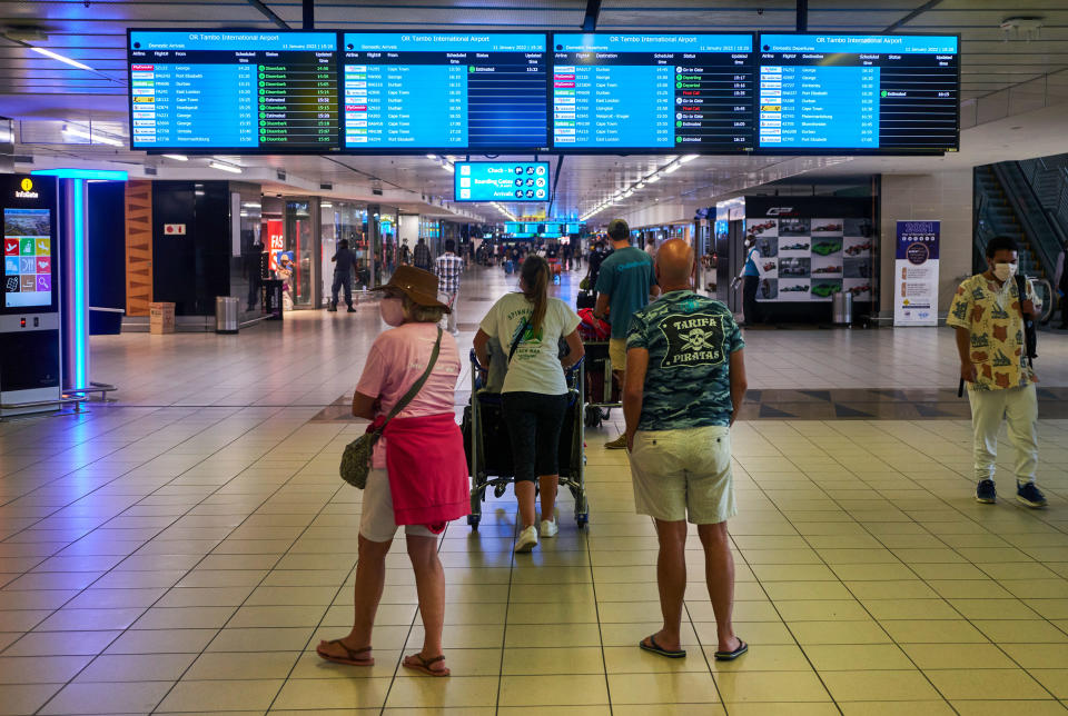 Passengers look at flight information boards inside the departures terminal at O.R. Tambo International Airport in Johannesburg, South Africa, January 11, 2022. / Credit: Waldo Swiegers/Bloomberg/Getty