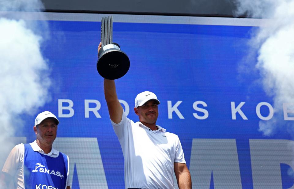 May 5, 2025; Singapore, SINGAPORE; Brooks Koepka celebrates with the trophy after winning LIV Golf Singapore at Sentosa Golf Club. Mandatory Credit: Edgar Su/Reuters via USA TODAY Sports
