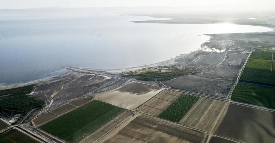 FILE - This May 1, 2015 aerial file photo shows the exposed lake bed of the Salton Sea evaporating near Niland, Calif. California officials have proposed spending nearly $400 million over 10 years to slow the shrinkage of the state's largest lake. Gov. Jerry Brown's administration on Thursday, March 16, 2017 unveiled a plan to build ponds on the northern and southern ends of the Salton Sea. It's expected to evaporate at an accelerated pace starting next year when the San Diego region no longer diverts water to the desert region. (AP Photo/Gregory Bull, File)